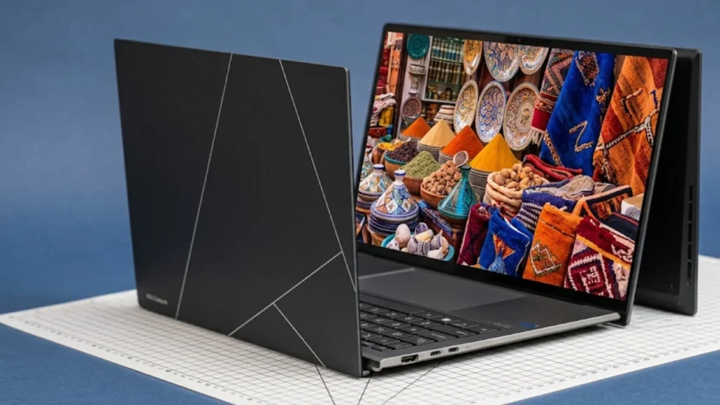 Top 10 Laptop Brands in 2026. An ASUS laptop with a unique geometric-patterned black lid, positioned open on a grid cutting mat to display a colorful, intricate mosaic wallpaper on the screen.